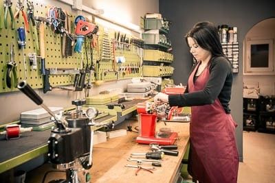 Junge Dame repariert Kaffeemaschine